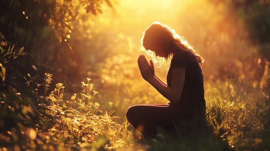 Woman kneeling and praying in nature during sunset, representing spiritual reflection and connection with God through prayer.